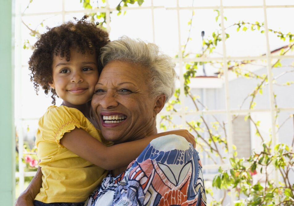 Woman and young girl embracing outdoors