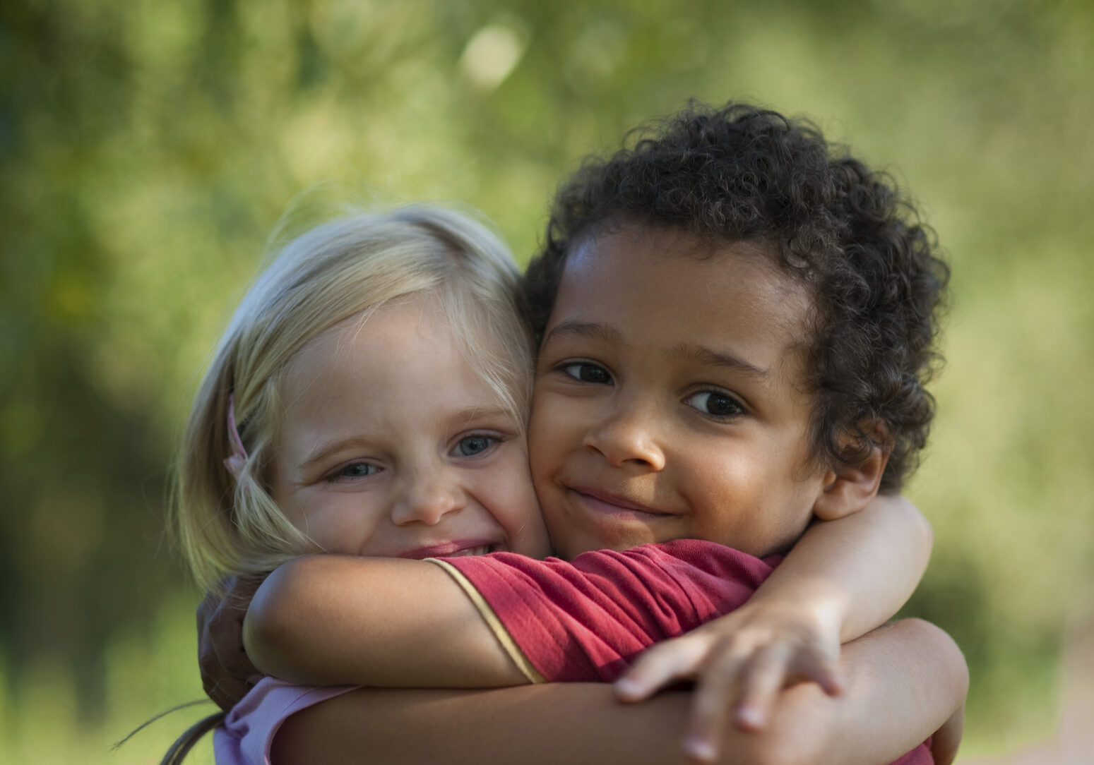 Multi-racial children hug eachother